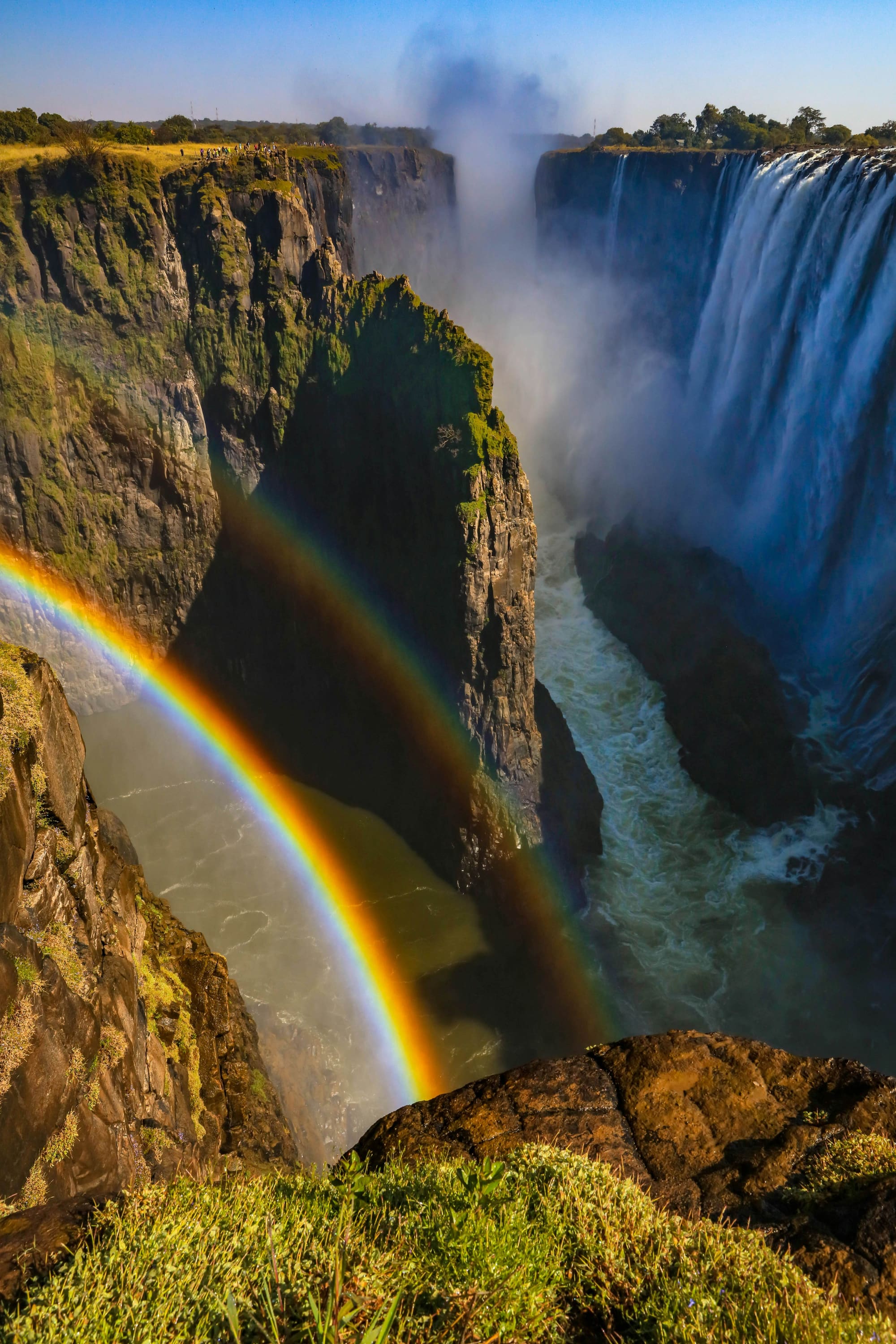 A vivid rainbow arcing across the spray of Victoria Falls